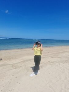 발리 해변에서 노란색 셔츠와 선글라스를 착용하고 여행을 즐기는 모습